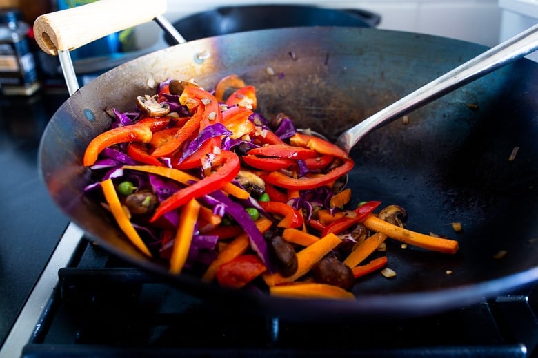 Here's a super tasty recipe for Vegan Kimchi Noodles, stir-fried with lots of healthy veggies you probably have on hand. Keep it vegan or add an egg, chicken or shrimp! Crispy tofu is also a delicious option here! #kimchi #kimchinoodles #kimchirecipes #vegannoodles