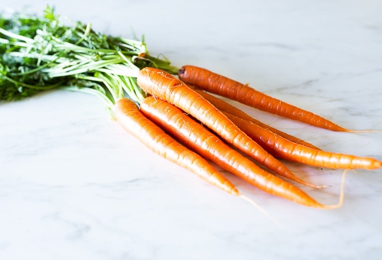 fresh carrot bunch with carrot tops.