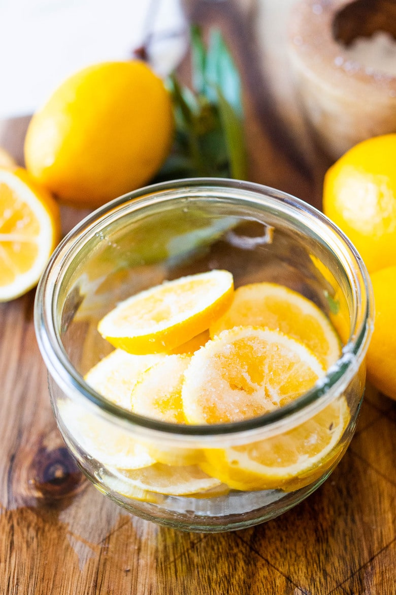 How to Preserve Lemons- a simple easy way to preserve lemons that only takes 10 minutes of hands-on time before letting mother nature take its course. Use in dressings, marinades, Middle Eastern Dishes and salad to add a burst of flavor. #preservedlemons