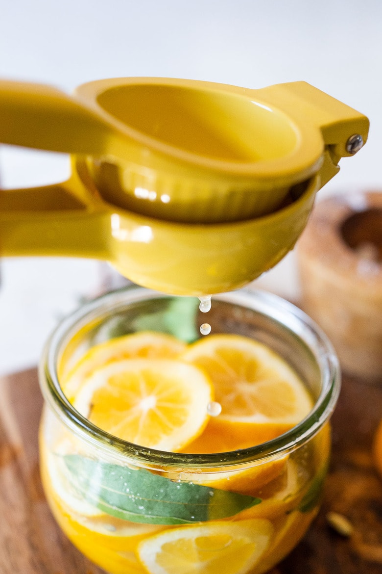 How to Preserve Lemons- a simple easy way to preserve lemons that only takes 10 minutes of hands-on time before letting mother nature take its course. Use in dressings, marinades, Middle Eastern Dishes and salad to add a burst of flavor. #preservedlemons