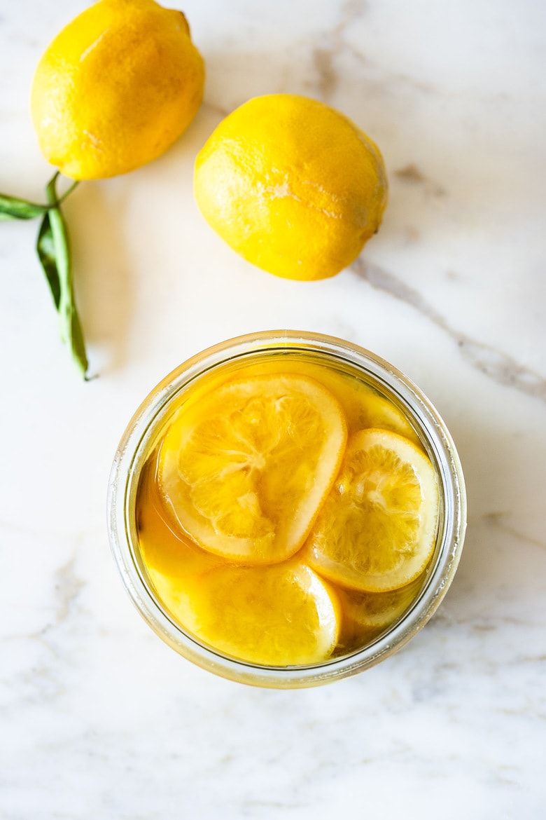 How to Preserve Lemons- a simple easy way to preserve lemons that only takes 10 minutes of hands-on time before letting mother nature take its course. Use in dressings, marinades, Middle Eastern Dishes and salad to add a burst of flavor. #preservedlemons