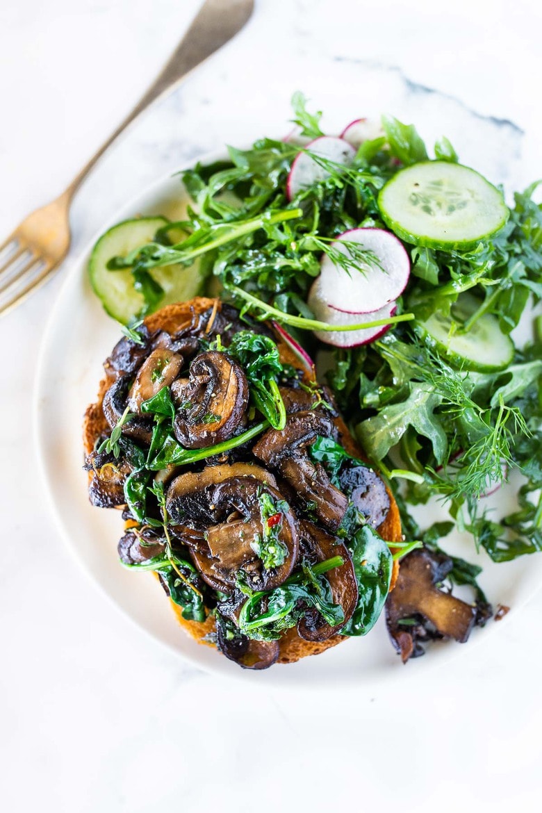 A simple healthy vegan recipe for Mushroom Toast with Spinach, Garlic, Thyme and lemon zest. Serve it as a meal with a hearty salad, or top it with an egg for breakfast. A great way to use up sourdough bread! #mushroomtoast