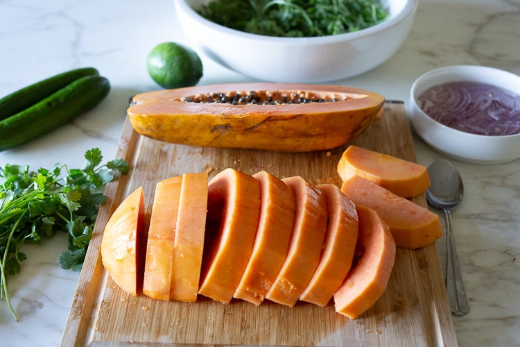 A simple Mexican-inspired Papaya Salad with cucumber, red onions, jalapeño over greens with a Cilantro Lime Dressing. #papayasalad 