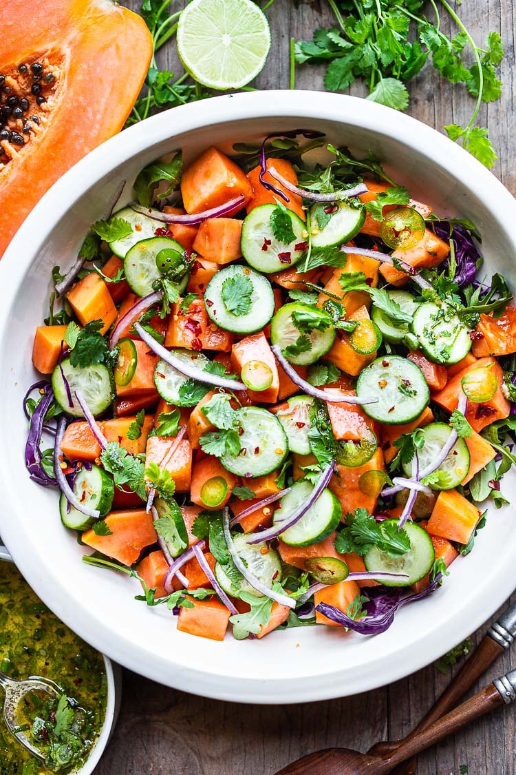 A simple Mexican-inspired Papaya Salad made with ripe papaya, with cucumber, red onions, jalapeño over greens with a Cilantro Lime Dressing. #papayasalad