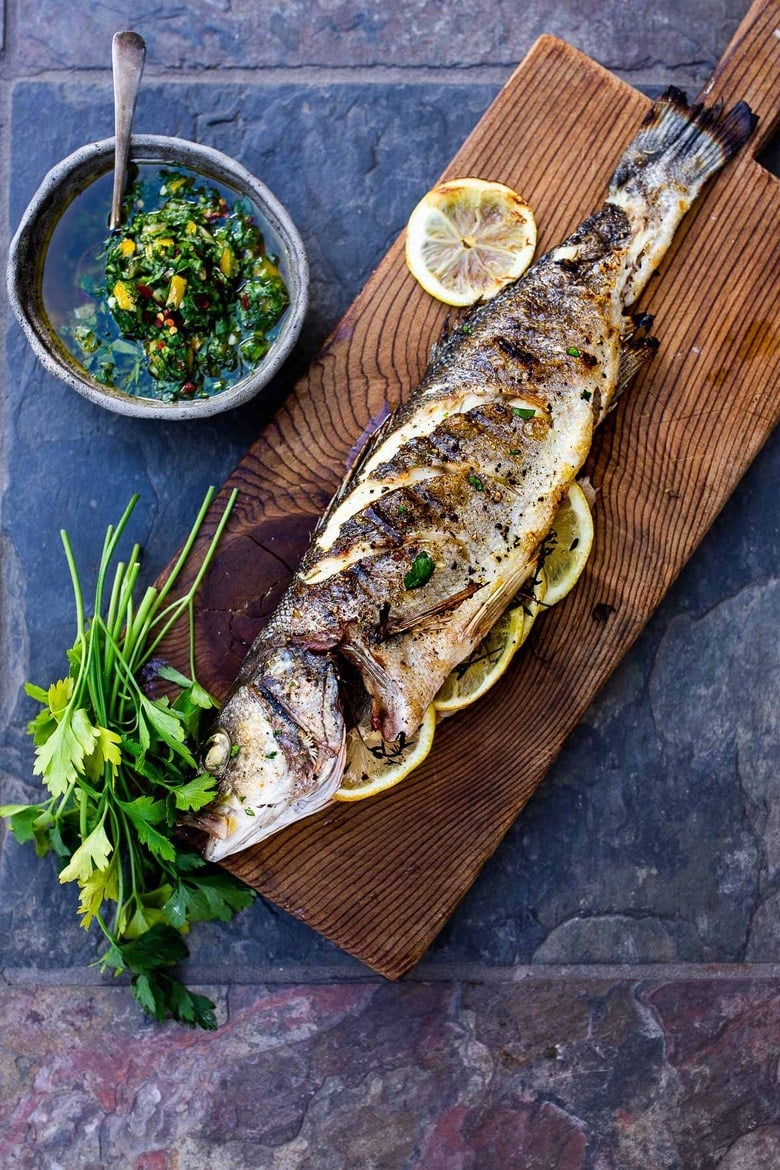 How to grill a whole fish (Branzino) topped with the most flavorful Preserved Lemon Gremolata, (Zesty Herb Sauce) in about 30 minutes flat! A simple easy Mediterranean dinner! #branzino #grilledfish #wholefish #grilledbranzino