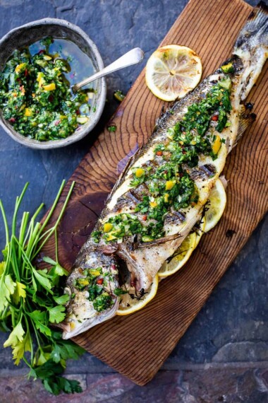 How to grill a whole fish (Branzino) topped with the most flavorful Preserved Lemon Gremolata, (Zesty Herb Sauce) in about 30 minutes flat! A simple easy Mediterranean dinner! #branzino #grilledfish #wholefish #grilledbranzino