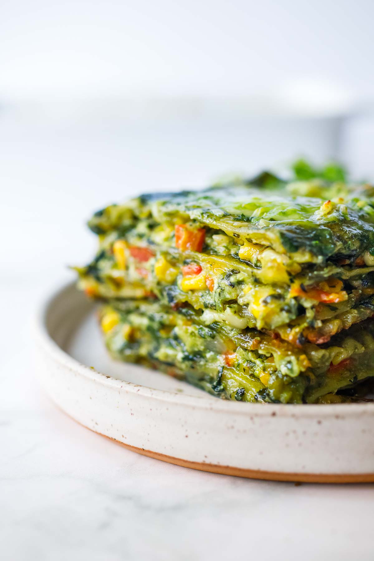 A delicious recipe for Spinach Lasagna filled with savory spinach and your choice of veggies and layered with a luscious Basil Spinach Sauce. Keep it vegetarian, or add chicken.
