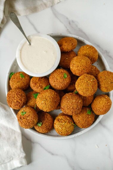 homemade falafel on a plate with tahini sauce