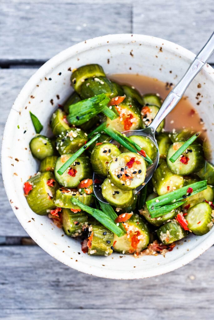 Kimchi Pickles in a pottery bowl with sesame seeds and scallions.