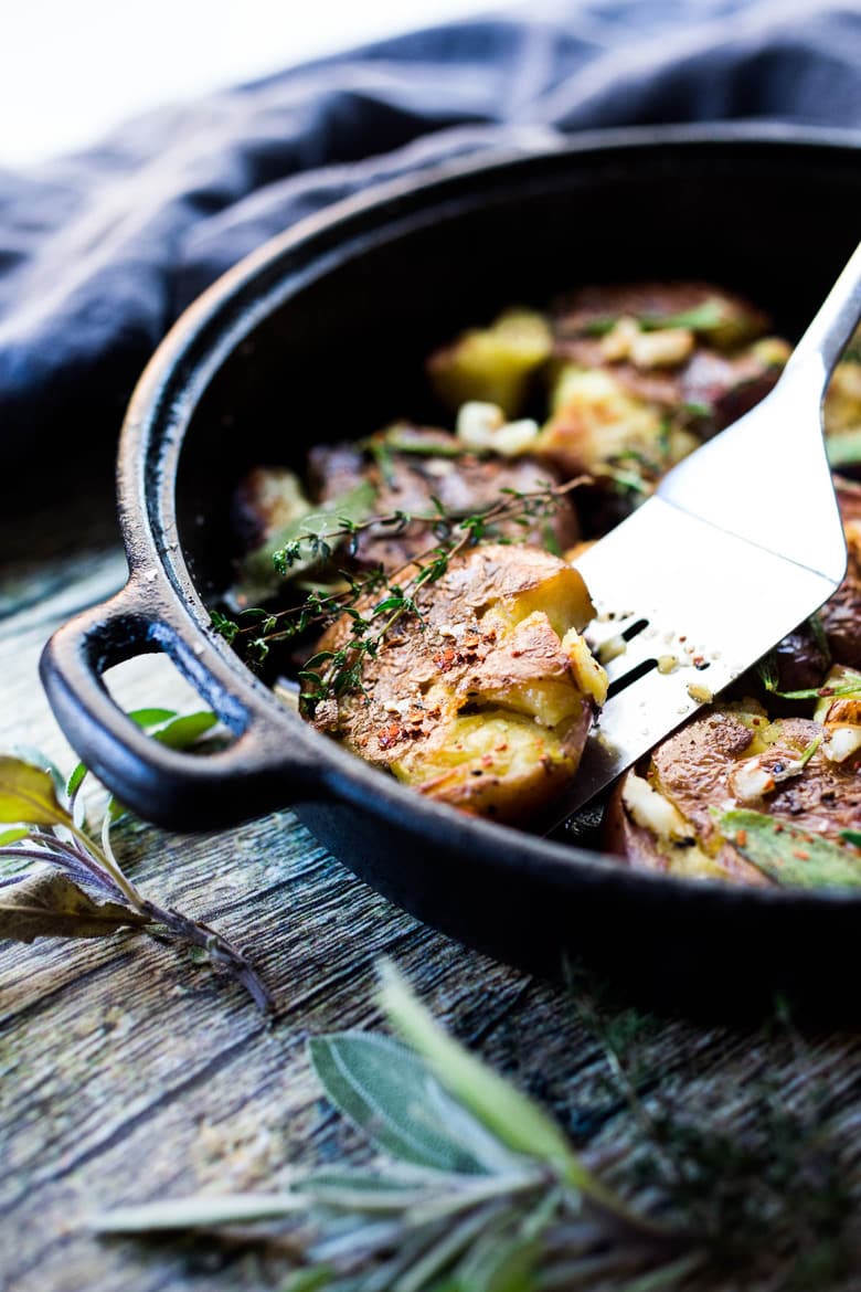 Crispy Smashed Potatoes with Garlic and Herbs- a healthy vegan side perfect for breakfast or dinner! #veganside #potoatoes #smashedpotatoes #veganpotatoes 