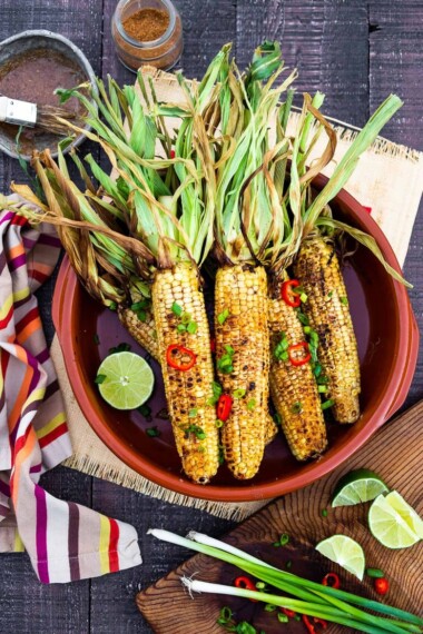 This Indian Masala Street Corn hails from the streets of Bombay. It's lathered with ghee and garam masala spice- a simple easy summer side dish to add to your next Indian feast! #grilledcorn #masalacorn #indiancorn