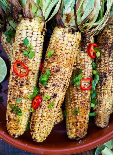 This Indian Masala Street Corn hails from the streets of Bombay. It's lathered with ghee and garam masala spice- a simple easy summer side dish to add to your next Indian feast! #grilledcorn #masalacorn #indiancorn