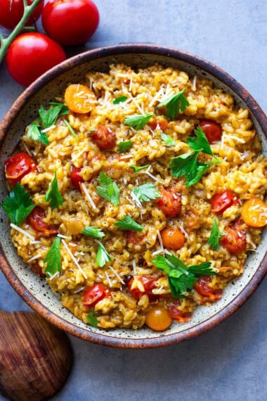 A summery Tomato Risotto highlighting juicy, sweet, cherry tomatoes, and infused with saffron.  Serve this as a vegetarian main course, a seasonal side dish, or top it off with smoky, pan-seared shrimp.