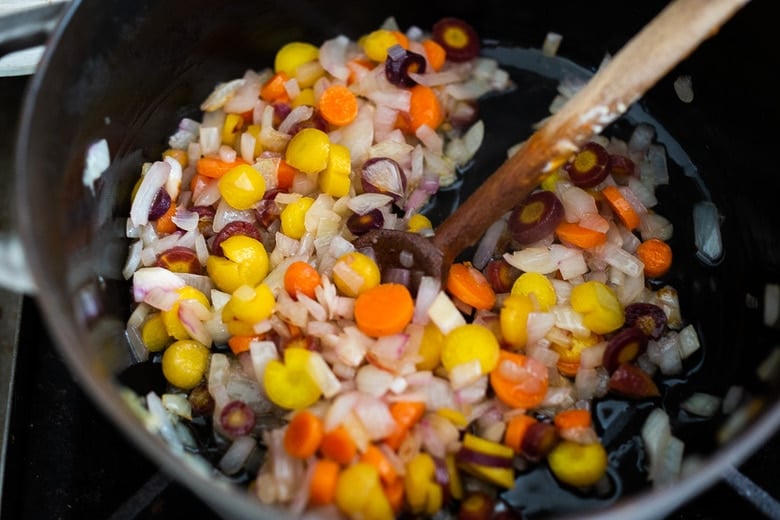 Sautéing carrots and onions for tomato soup.