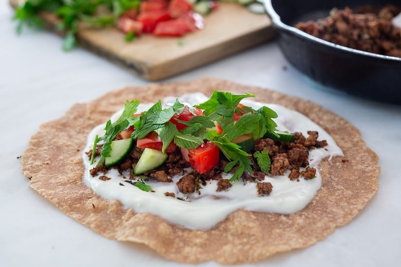 Fast and flavorful, Turkish Lamb Wraps are made with savory ground lamb seasoned with flavorful Turkish spices, wrapped up in a tortilla with labneh, cucumbers, tomatoes, mint, parsley and peppery watercress. A simple weeknight dinner that can be made in under 30 minutes. #lamb #americanlamb #lambwrap #turkishwrap 