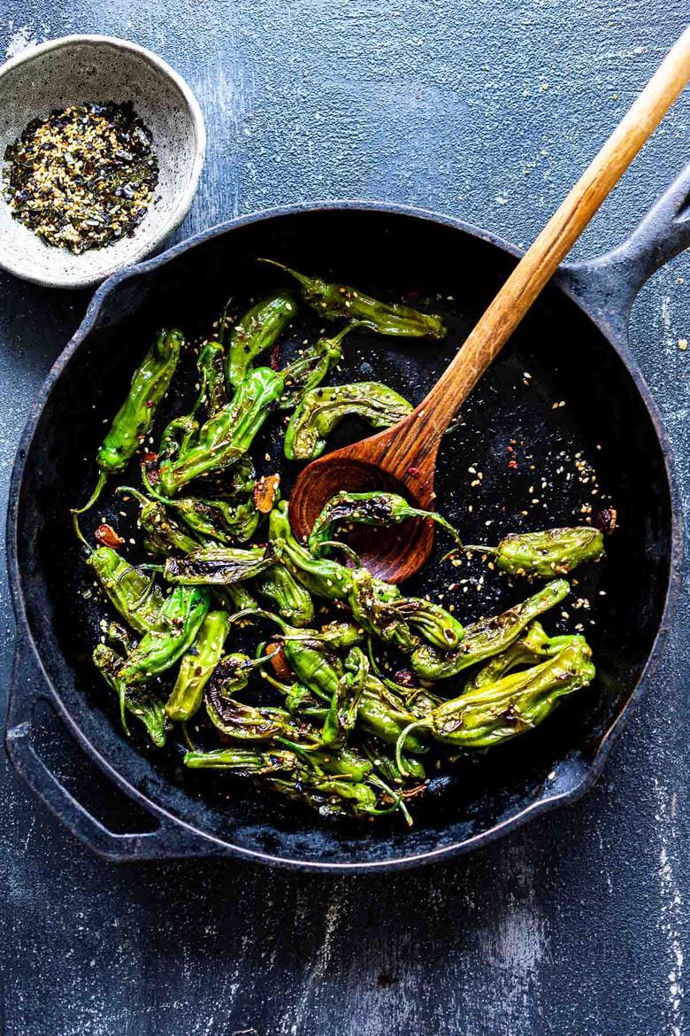 A simple flavorful recipe for Blistered Shishito Peppers with crispy garlic and Furikake Seasoning- a delicious appetizer that can be made in minutes! Vegan. #shishito #blistered #peppers #furikake 