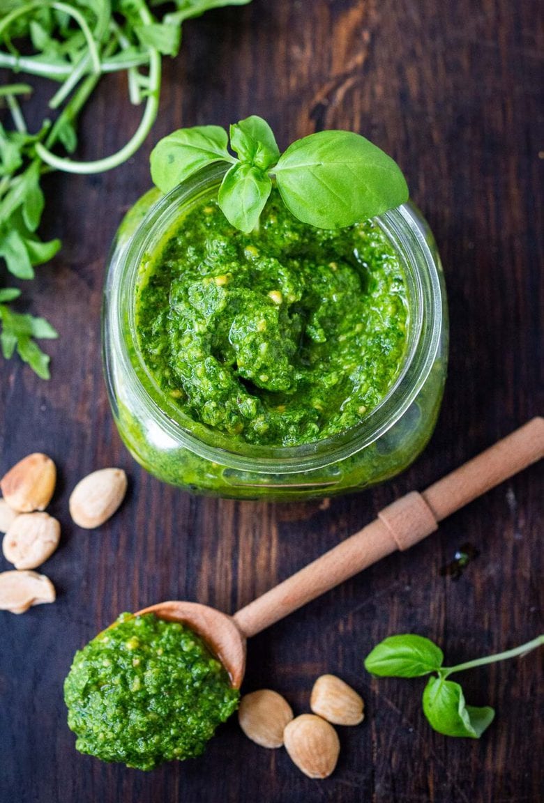 A simple recipe for Arugula Almond Pesto. Vegan and made without pinenuts, it adds a peppery brightness to dishes you are already making! #pesto #arugulapesto #almondpesto