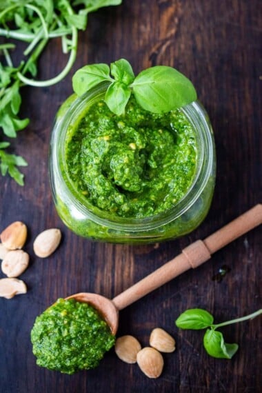 A simple recipe for Arugula Almond Pesto. Vegan and made without pinenuts, it adds a peppery brightness to dishes you are already making! #pesto #arugulapesto #almondpesto