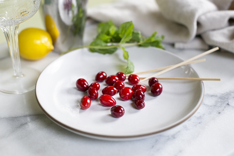 A festive holiday cocktail made with assertive rye whiskey, enlivened with tart cranberry & lemon, the whole softened by 2 festive liqueurs; garnished with a bit of holiday fruit, or (depending on how you've been this year) - a lump of "coal".