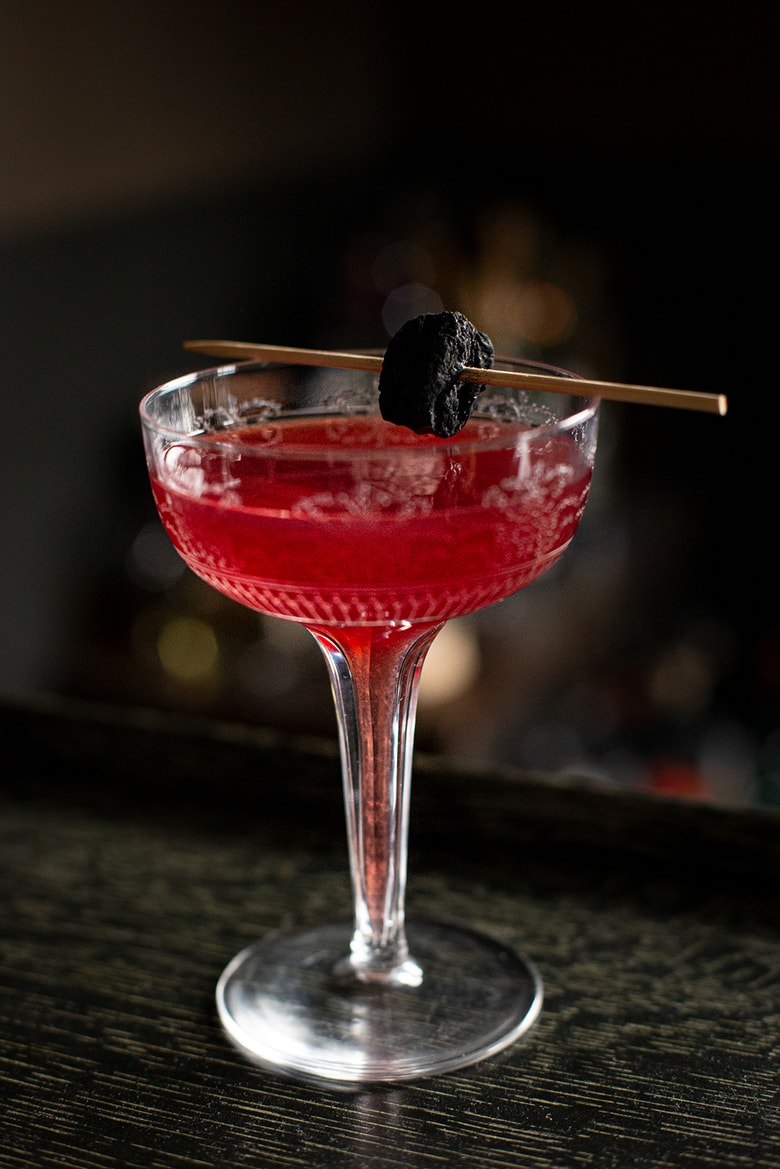 A festive holiday cocktail made with assertive rye whiskey, enlivened with tart cranberry & lemon, the whole softened by 2 festive liqueurs; garnished with a bit of holiday fruit, or (depending on how you've been this year) - a lump of "coal".