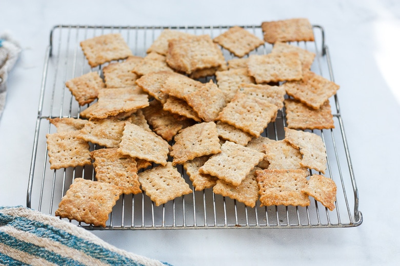 homemade sourdough crackers laying on a cooling rack.