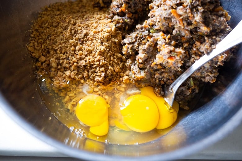 mixing bowl with mushroom loaf mixture, pulsed walnuts, and eggs.