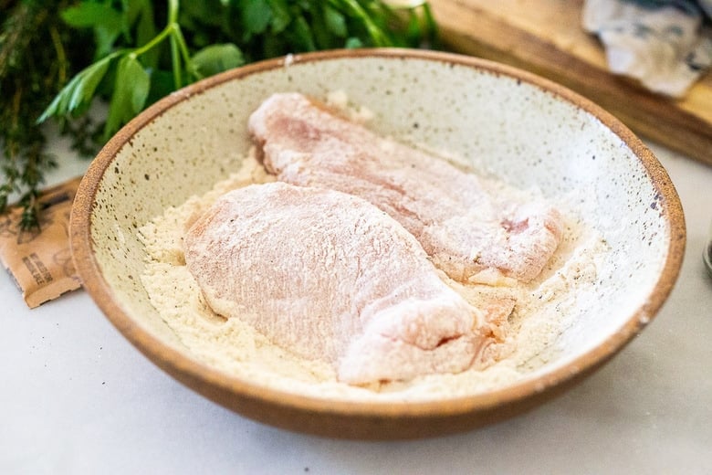 dredging the chicken in flour mixture