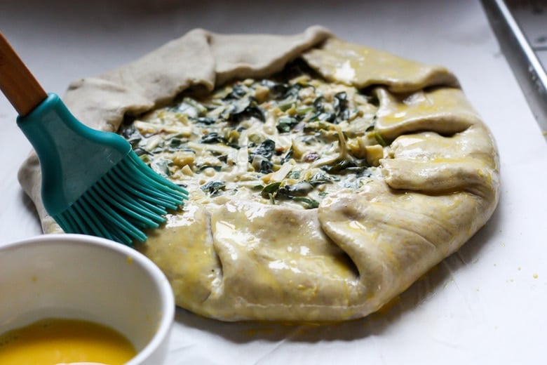 Pour in the egg batter and brush the outer crust with egg mixture. 