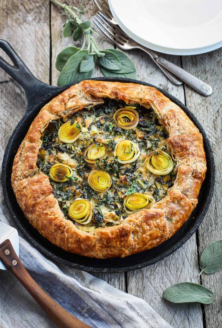 A Savory Leek Galette, made with a free-formed tender flakey crust enclosing a luscious melt in your mouth succulent filling. Leeks and kale marry with gruyere and mascarpone making the perfect balance of decadent and wholesome! The Galette dough is the secret here! #galette #savorygalette #tart #leeks