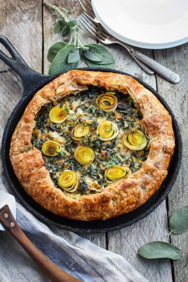 A Savory Leek Galette, made with a free-formed tender flakey crust enclosing a luscious melt in your mouth succulent filling. Leeks and kale marry with gruyere and mascarpone making the perfect balance of decadent and wholesome! The Galette dough is the secret here! #galette #savorygalette #tart #leeks