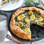 Beautiful and delicious Savory Leek Galette. Made with a free-formed tender flakey crust enclosing a luscious melt in your mouth succulent filling. Leeks and kale marry with gruyere and mascarpone making the perfect balance of decadent and wholesome! The Galette dough is the secret here! #galette #savorygalette #tart #leeks