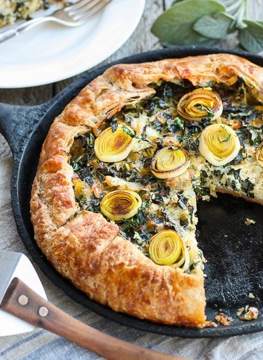Beautiful and delicious Savory Leek Galette.   Made with a free-formed tender flakey crust enclosing a luscious melt in your mouth succulent filling. Leeks and kale marry with gruyere and mascarpone making the perfect balance of decadent and wholesome! The Galette dough is the secret here! #galette #savorygalette #tart #leeks