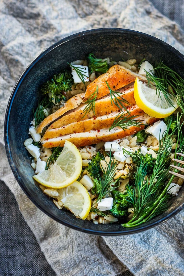 One-pan Baked Broccoli Chicken with orzo, feta and lemon served in a bowl.