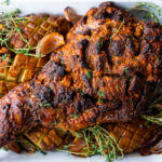 A simple recipe for Leg of Lamb with a Harissa Yogurt Crust. This bone-in lamb leg yields a beautiful flavorful crust with juicy tender meat. #legoflamb #lamb #fanoflamb #lambroast #harrisa