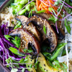 Miso Mushroom Bowl with brown rice, avocado, cabbage, carrots, daikon, edamame and a Miso Ginger Dressing. Vegan and Gluten free.