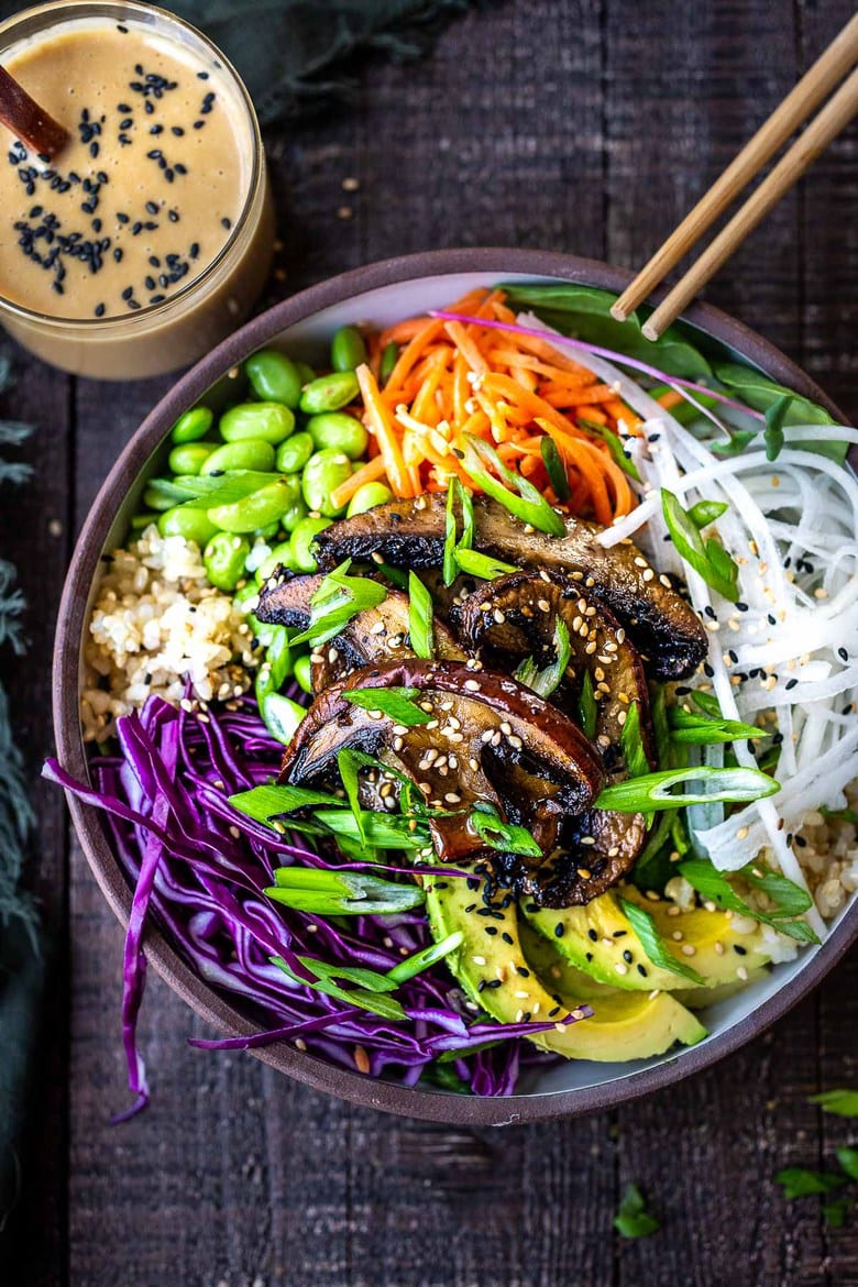 A flavorful Miso Mushroom Bowl with brown rice, avocado, cabbage, carrots, daikon, edamame and a Miso Ginger Dressing. Vegan and Gluten free. #bowl #veganbowl #vegandinner #mushroombowl 