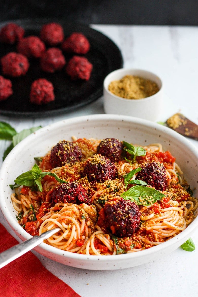 Vegan Spaghetti and Beetballs!  A beautiful twist on the comforting familiar classic.  Beets, black beans, walnuts and basil make these plant-based meatballs scrumptious and so satisfying.  Top with an easy rustic tomato sauce for a meal the whole family will love! #vegan #veganmeatballs #beetballs #spaghetti #veganspaghetti 