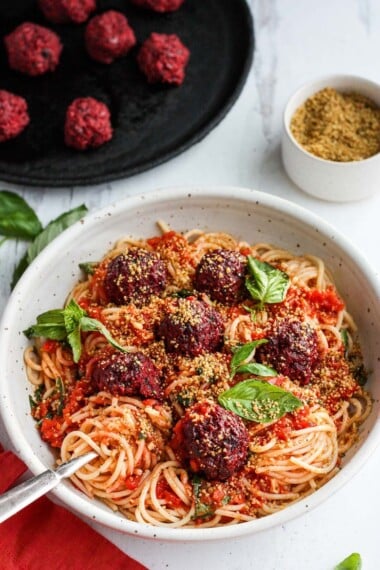 Vegan Spaghetti and Beetballs!  A beautiful twist on the comforting familiar classic.  Beets, black beans, walnuts and basil make these plant-based meatballs scrumptious and so satisfying.  Top with an easy rustic tomato sauce for a meal the whole family will love! #vegan #veganmeatballs #beetballs #spaghetti #veganspaghetti
