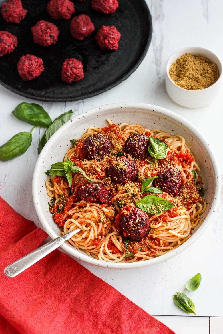 Vegan Spaghetti and Beetballs!  A beautiful twist on the comforting familiar classic.  Beets, black beans, walnuts and basil make these plant-based meatballs scrumptious and so satisfying.  Top with an easy rustic tomato sauce for a meal the whole family will love! #vegan #veganmeatballs #beetballs #spaghetti #veganspaghetti 