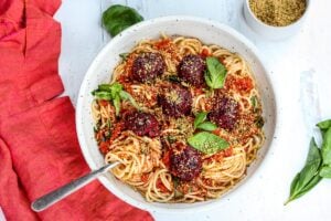 Vegan Spaghetti and Beetballs!  A beautiful twist on the comforting familiar classic.  Beets, black beans, walnuts and basil make these plant-based meatballs scrumptious and so satisfying.  Top with an easy rustic tomato sauce for a meal the whole family will love! #vegan #veganmeatballs #beetballs #spaghetti #veganspaghetti