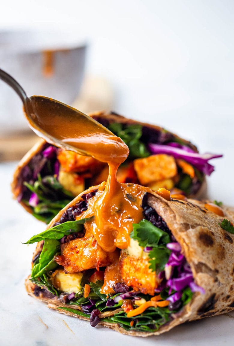 Thai Burrito with Peanut Sauce, baked peanut Tofu, black rice, spicy sriracha black beans and shredded crunchy veggies all wrapped up in a warm, whole wheat tortilla. #vegan #veganburrito #thaiburrito