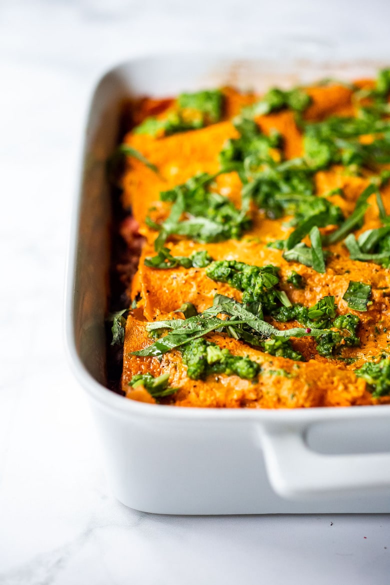 This Vegan Lasagna is made with a robust mushroom-spinach bolognese sauce, fresh basil, vegan ricotta and no-boil lasagna noodles, topped off with a creamy marinara sauce, drizzled with Arugula Basil Pesto. Vegan comfort food at its best! #veganlasagna #vegandinnerrecipes #vegan #lasagna #mushroombolognese 