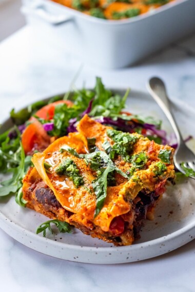 This Vegan Lasagna is made with a robust mushroom-spinach bolognese sauce, fresh basil, vegan ricotta and no-boil lasagna noodles, topped off with a creamy marinara sauce, drizzled with Arugula Basil Pesto. Vegan comfort food at its best! #veganlasagna #vegandinnerrecipes #vegan #lasagna #mushroombolognese