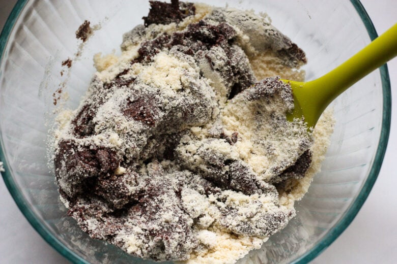 a glass bowl with cookie batter and a spatula.