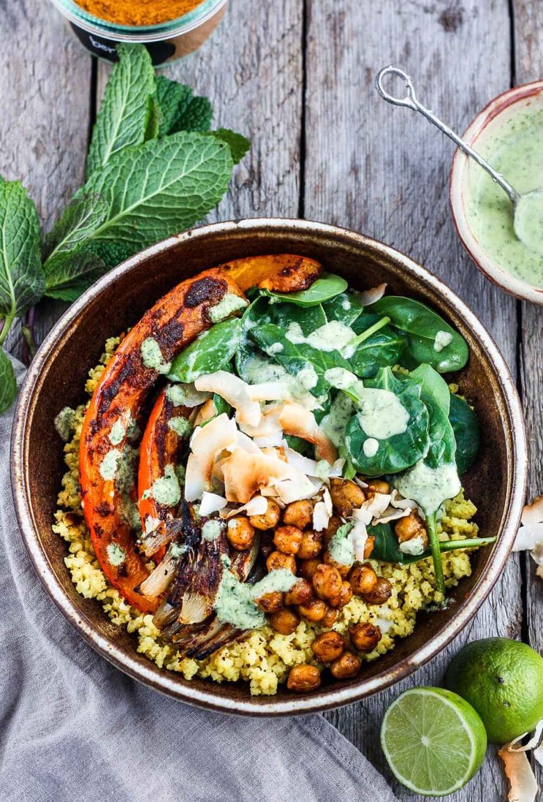 Coconut Millet Bowl with Berbere-Spiced Kabocha Squash, chickpeas, shallots, and spinach drizzled with coconut lime mint sauce.  A vegan, plant-based meal, full of vibrant flavor and spice.