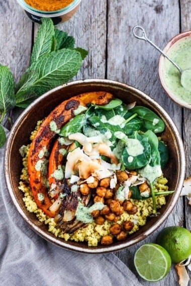 Coconut Millet Bowl with Berbere-Spiced Kabocha Squash, chickpeas, shallots, and spinach drizzled with coconut lime mint sauce.  A vegan, plant-based meal, full of vibrant flavor and spice.