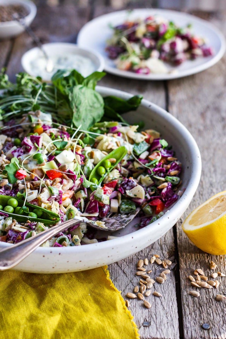 This Rainbow Chopped Salad is crunchy, colorful and nutritious! Tossed with a lemony herbed greek yogurt dressing, it is easy to make and easy to adapt. Perfect for meal prep, this salad keeps for 4 days in the fridge. #choppedsalad #yogurtdressing 