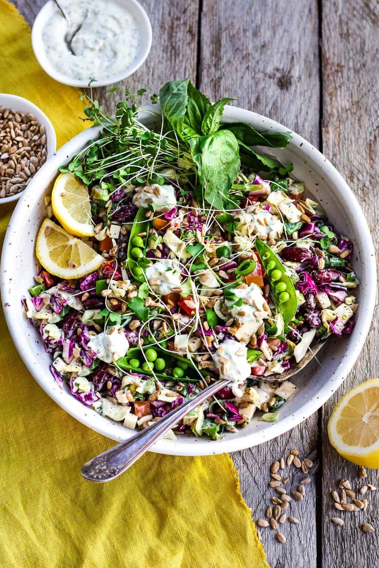 This Rainbow Chopped Salad is crunchy, colorful and nutritious! Tossed with a lemony herbed greek yogurt dressing, it is easy to make and easy to adapt. Perfect for meal prep, this salad keeps for 4 days in the fridge. #choppedsalad #yogurtdressing