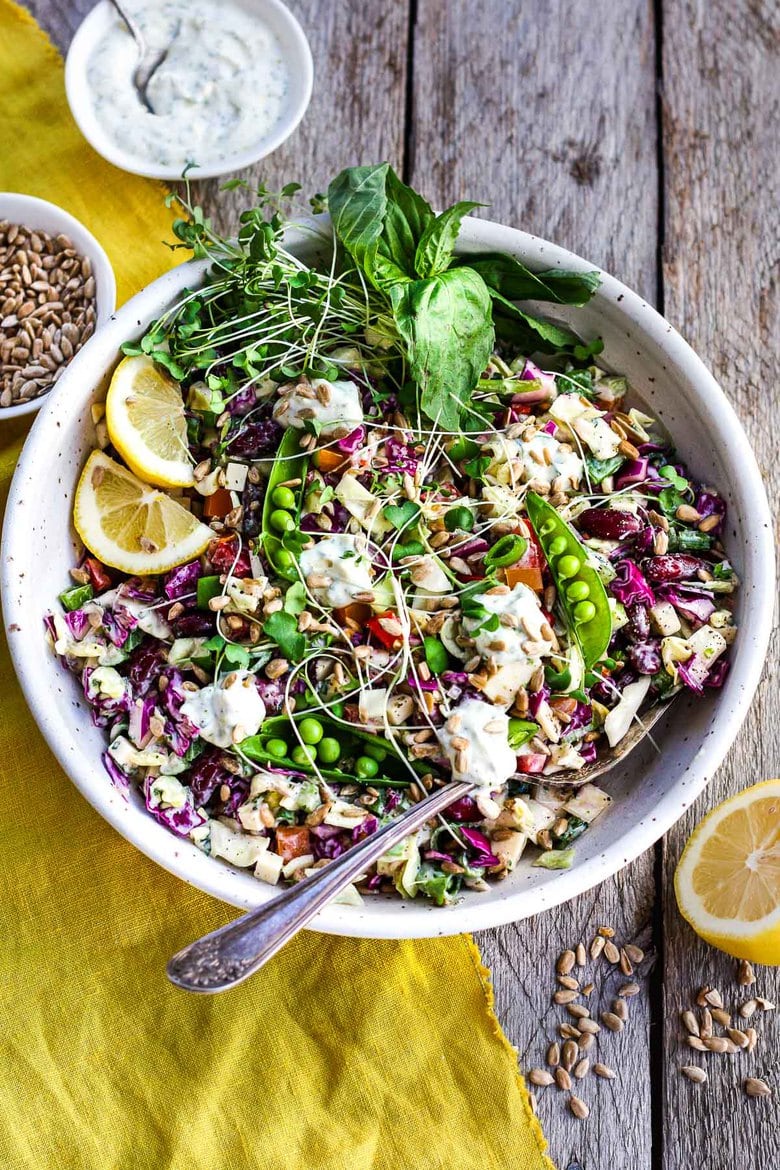 This Rainbow Chopped Salad is crunchy, colorful and nutritious! Tossed with a lemony herbed greek yogurt dressing, it is easy to make and easy to adapt. Perfect for meal prep, this salad keeps for 4 days in the fridge. #choppedsalad #yogurtdressing 