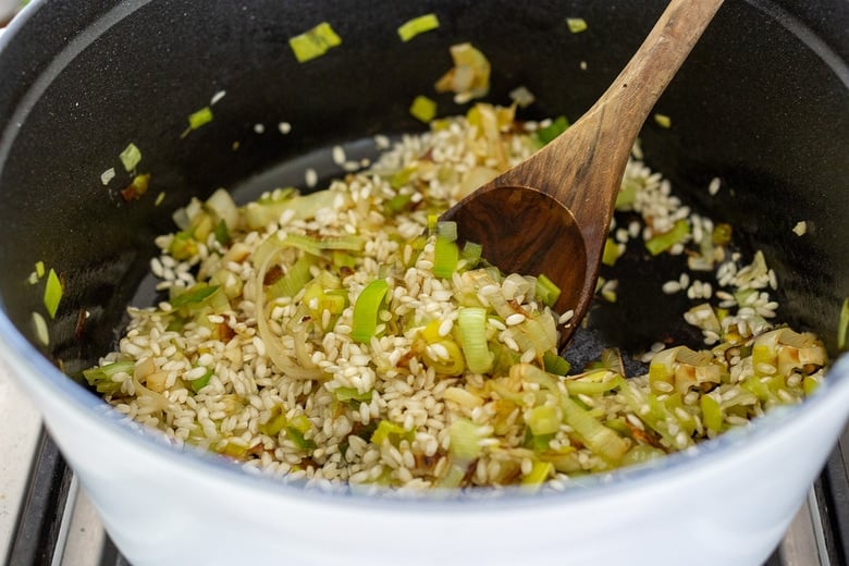 pot with leeks and arborio rice, stirring with wooden spoon.